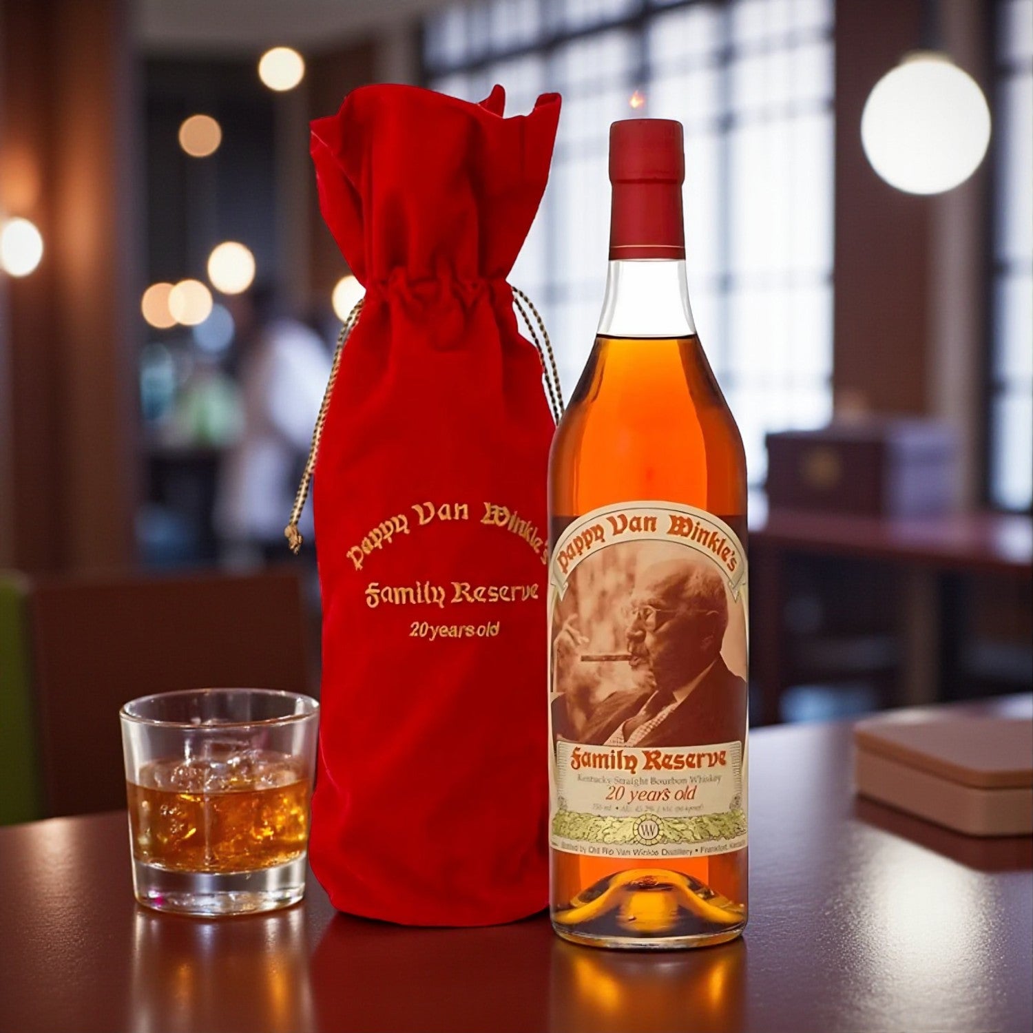 Collector’s Pappy Van Winkle Family Reserve 20 Year Bourbon bottle with red velvet bag and glass of bourbon on wooden table under warm bar lighting – Rare Bourbon Shop lifestyle photo