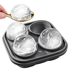 Premium whiskey ice sphere mold with spoon and large round ice balls on white background