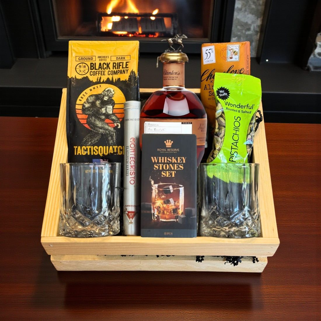 Collector’s Blanton’s Straight From the Barrel Bourbon Gift Crate with coffee, chocolate, pistachios, cigar, whiskey stones, and old-fashioned glasses displayed near fireplace – Rare Bourbon Shop lifestyle photo