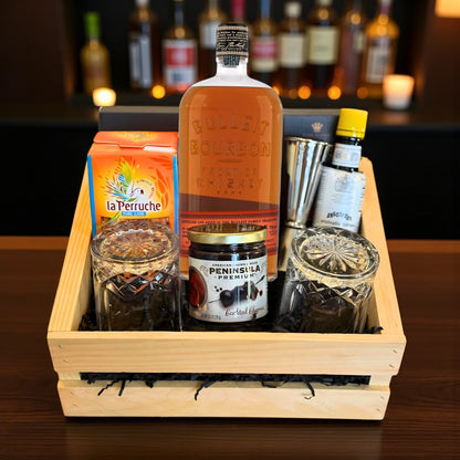 Collector’s Bulleit Bourbon Old Fashioned Gift Crate with whiskey, bar tools, cocktail cherries, bitters, and glasses on bar – Rare Bourbon Shop lifestyle photo