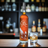 Collector’s Eagle Rare 10 Year Bourbon bottle on wooden bar beside glass of bourbon on ice – Rare Bourbon Shop lifestyle photo