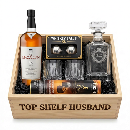 The Macallan 18 Years Old Double Cask Highland Single Malt Scotch Whisky Top Shelf Husband Gift Crate in natural pine wood with burned lettering, featuring "Top Shelf Husband" etched crystal decanter with royal crest design, two crystal cut old fashioned glasses, Whiskey Balls XXL stainless steel ice spheres, and Turin chocolates on white background, straight-on front view