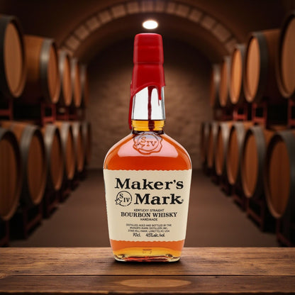 Maker’s Mark Kentucky Straight Bourbon Whisky bottle with red wax seal on wooden table surrounded by bourbon barrels – Rare Bourbon Shop lifestyle photo