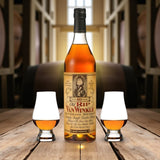 Collector’s Old Rip Van Winkle 10 Year Bourbon Gift Set with two Glencairn glasses on wooden table among bourbon barrels – Rare Bourbon Shop lifestyle photo
